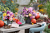 Herbststräuße aus Rosen, Schmuckkörbchen und Astern, Speisekürbisse, Tassen und Servietten, Tagpfauenauge auf Blüte, Schale mit Himbeeren
