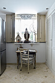 Desk below window with folding shutters and shabby-chic decorations