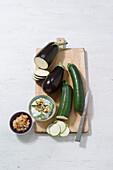 Zucchini-Feta-Creme und Auberginencreme mit frischem Gemüse auf Holzbrett