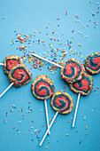 Vegan shortbread biscuits with colourful sugar sprinkles on a stick