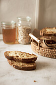 Geröstete Brotscheiben, im Hintergrund Honig und Haferflocken