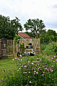 Frühsommer-Garten mit Akelei im Beet und Sitzplatz am Raumteiler