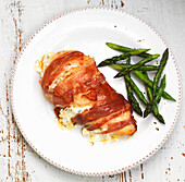 Stuffed chicken breast wrapped with Parma ham and green asparagus