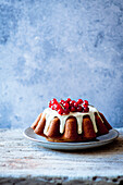 A Bundt cake with icing and redcurrants