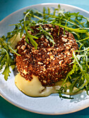 Baked camembert in a spiced coating with a rocket salad