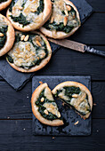 Vegan mini pizzas with spinach, pine nuts and almond cheese