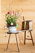 Birch wreath with tulips, flowering twigs and bird figurines in a basket