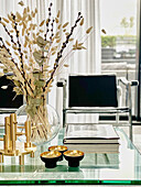 Blick über Glastisch mit Vase auf verchromten Stuhl vor Terrassentür