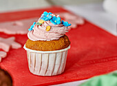 Cupcake mit rosa Frosting und Zuckerblüten