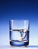 Glass of water with vitamin tablet