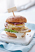 Cajun chicken burger with pineapple and red onions