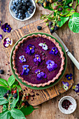 Beeren-Ganache-Kuchen garniert mit Hornveilchenblüten