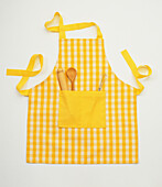 Apron with wooden spoon, rolling pin and whisk