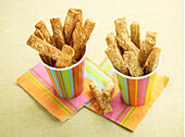 Cheese straws in colourful paper cups