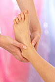 Reflexologist massaging child's ankle