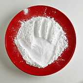 Hand print in plate of flour