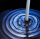 Candle in pool of water
