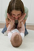 Woman leaning over baby girl