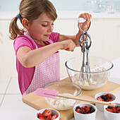 Girl whisking cream in a mixing bowl