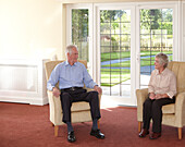 Older man and woman sitting in armchairs