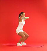 Woman squatting while holding dumbbells