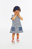 Little girl with both hands covering her face