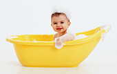 Baby girl in yellow bath tub