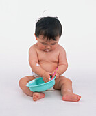 Baby holding a plastic bowl