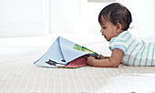 Baby girl reading fabric picture book