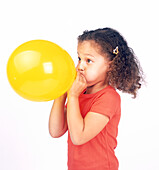 Girl inflating yellow balloon