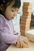 Girl holding block on table