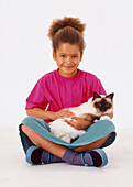 Smiling girl holding Birman cat on her lap