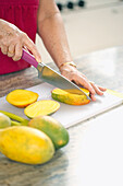 Woman chopping mangoes