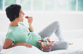 Woman in early stages of pregnancy eating strawberries