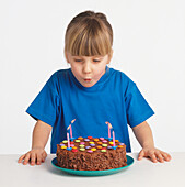 Girl blowing four candles on birthday cake