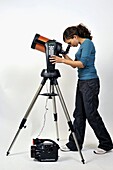 Woman looking through eyepiece on astronomical telescope