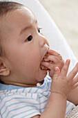 Baby boy stuffing food in his mouth