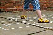 Legs of girl playing hopscotch