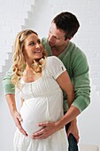 Man standing behind his pregnant partner