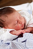 Baby girl sleeping with her head resting on her arm