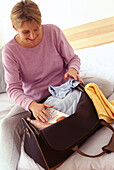 Pregnant woman packing travel bag