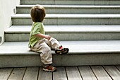 Toddler sitting at the bottom of set of steps