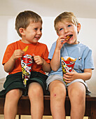 Boys eating chips from a paper cone