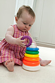 Baby girl playing with plastic hoop toy