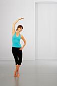 Woman performing stretching exercise in ballet position