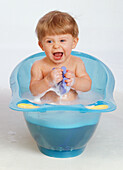 Boy in bath washing himself