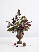 Miniature floral urn with fruit decorations