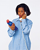 Woman on telephone looking at toilet cleaner bottle