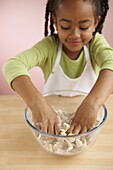 Girl rubbing butter into flour in bowl