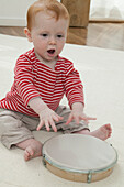 Baby boy playing with tambourine